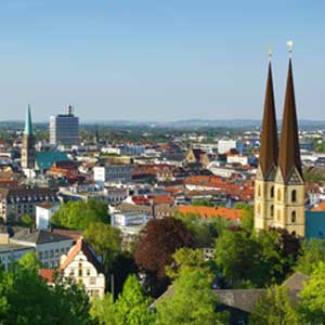 Cityscape with Gothic church towers and modern skyline, perfect backdrop for an exclusive escort service experience in a vibrant German city.
